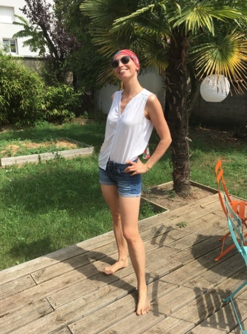 Angeline posant dans un jardin pendant son parcours de soins mis en place à l'annonce de cancer