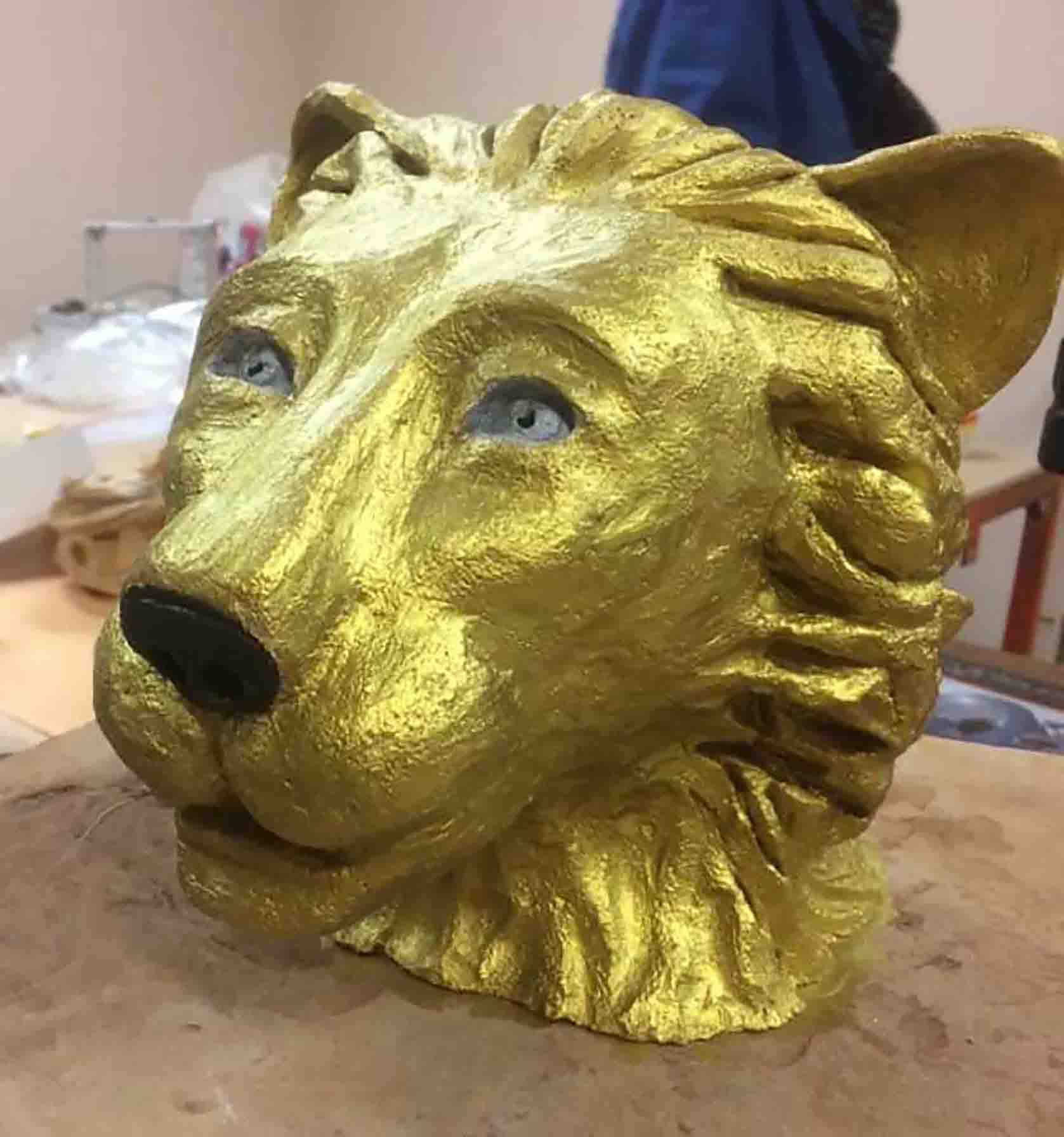 Sculpture d'une tête de lion dorée réalisée par Béatrice, ancienne patiente du cancer, qui utilise l'art comme thérapie complémentaire