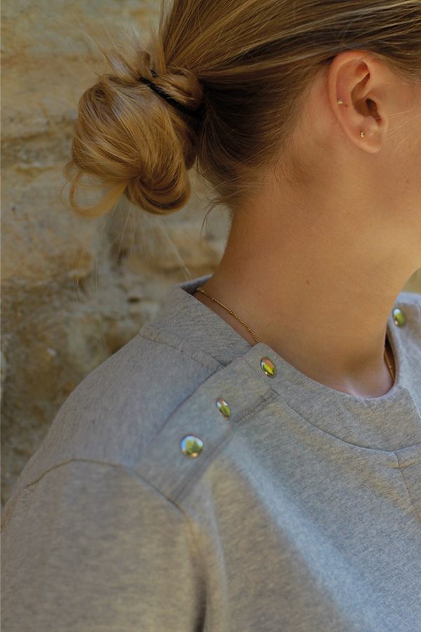 Zoom sur les boutons-pression de l'épaule du sweatshirt pour mieux vivre avec une chambre implantable